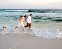This happy couple and their dog, enjoy a run in the surf after the wedding ceremony.